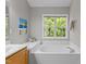 Well lit bathroom with a large window, a garden tub, and neutral paint at 110 Fairchild Downs Pl, Cary, NC 27518