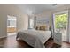 Bright bedroom featuring a queen bed, neutral walls, wood floors, and two windows letting in plenty of natural light at 110 Fairchild Downs Pl, Cary, NC 27518