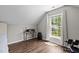 Bright bedroom featuring hardwood floors, a large window, and an alcove for a desk or workout area at 110 Fairchild Downs Pl, Cary, NC 27518