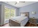 Well lit bedroom featuring hardwood floors, a blue colored walls, and a large window at 110 Fairchild Downs Pl, Cary, NC 27518