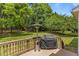 Backyard deck with covered grill and patio heater surrounded by mature trees and a spacious lawn at 110 Fairchild Downs Pl, Cary, NC 27518
