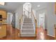 Bright foyer with a carpeted staircase and hardwood floors leading to the kitchen at 110 Fairchild Downs Pl, Cary, NC 27518