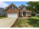 Charming two-story brick home with a well-manicured lawn and an attached two-car garage at 110 Fairchild Downs Pl, Cary, NC 27518