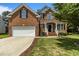 Charming two-story brick home with a well-manicured lawn and a two-car garage at 110 Fairchild Downs Pl, Cary, NC 27518
