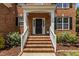 Inviting front porch with brick steps, white railings, and decorative plantings at 110 Fairchild Downs Pl, Cary, NC 27518