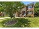 Charming two-story brick home with a well-manicured lawn, mature tree, and inviting front porch at 110 Fairchild Downs Pl, Cary, NC 27518