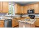 Spacious kitchen features granite countertops, natural wood cabinetry, and stainless steel appliances at 110 Fairchild Downs Pl, Cary, NC 27518