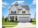 Charming two-story home with a manicured lawn, attached garage, and classic architectural details at 1101 Hazelmist Dr, Youngsville, NC 27596