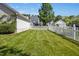 Well-manicured backyard features a lush lawn and white picket fence at 111 Chancellors Ridge Dr, Durham, NC 27713