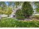 Expansive front yard with lush green grass, mature trees and shrubs, and a white picket fence at 111 Chancellors Ridge Dr, Durham, NC 27713