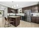A well-equipped kitchen features dark cabinets, stainless steel appliances, a granite island, and hardwood floors at 111 Chancellors Ridge Dr, Durham, NC 27713