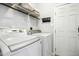 Bright laundry room with washer, dryer, storage shelf, and door to outside at 111 Chancellors Ridge Dr, Durham, NC 27713