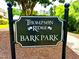 Thompson Ridge Bark Park sign surrounded by trees and wood mulch at 114 Constitution Dr, Durham, NC 27705