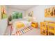 Bright bedroom features a sunny color palette, playful decor, and a view to the outdoors at 114 Constitution Dr, Durham, NC 27705
