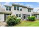Exterior view of townhouse features multiple screened-in porches, lawn, and mature landscaping at 114 Constitution Dr, Durham, NC 27705