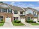 Townhome exterior features stone accents, attached garages, and well-maintained landscaping at 114 Constitution Dr, Durham, NC 27705
