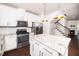 Bright modern kitchen with white cabinets, stainless appliances, granite island and countertops, and wood floors at 114 Constitution Dr, Durham, NC 27705