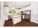 Bright kitchen featuring white cabinets, stainless steel appliances, granite countertops, and dark hardwood floors at 114 Constitution Dr, Durham, NC 27705