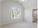 Neutral bedroom featuring large window allowing natural light, and ensuite bathroom at 117 Arborhill Ln, Holly Springs, NC 27540