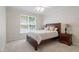 Cozy bedroom featuring carpet, a comfortable bed, a window, and matching nightstands with lamps at 117 Arborhill Ln, Holly Springs, NC 27540