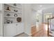 Entryway with hardwood floors, staircase, built-in shelving, and bright natural light from a nearby window and door at 117 Arborhill Ln, Holly Springs, NC 27540