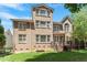 The brick home boasts a deck, large windows, and lush landscaping, creating a serene outdoor experience at 117 Arborhill Ln, Holly Springs, NC 27540