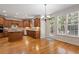 Kitchen with wooden cabinets, hardwood floors, an island, and an exterior door with lots of light at 117 Arborhill Ln, Holly Springs, NC 27540