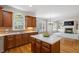 Open-concept kitchen with an island, hardwood floors, and view into the living area with fireplace at 117 Arborhill Ln, Holly Springs, NC 27540