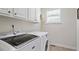 Laundry room with white cabinetry and modern appliances, perfect for efficient home management at 117 Arborhill Ln, Holly Springs, NC 27540