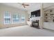 Cozy living room features a fireplace with built-in shelving and large windows for plenty of light, creating a comfortable space at 117 Arborhill Ln, Holly Springs, NC 27540