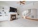 Bright living room features fireplace with shelving, ceiling fan, and seamless access to the adjacent dining area and staircase at 117 Arborhill Ln, Holly Springs, NC 27540