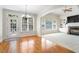 Bright living room featuring hardwood floors, large windows, and an open archway to a carpeted seating area at 117 Arborhill Ln, Holly Springs, NC 27540