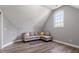 Comfortable living room featuring hardwood floors, gray paint, and a gray sofa with decorative pillows at 117 Arborhill Ln, Holly Springs, NC 27540