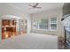 Bright living room with large windows, fireplace, ceiling fan, and open access to the kitchen, creating a spacious and connected area at 117 Arborhill Ln, Holly Springs, NC 27540