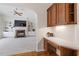 Built-in office nook with wooden cabinets, drawers, countertop, and view into the carpeted living room at 117 Arborhill Ln, Holly Springs, NC 27540