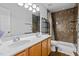 Bathroom featuring double sinks with wood cabinets, and a shower with decorative tile and grab bars at 118 Brandi Dr, Rolesville, NC 27571