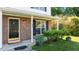 Close-up of a front entrance featuring a stylish black door, brick facade, and landscaped garden at 118 Brandi Dr, Rolesville, NC 27571