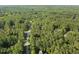 Aerial view showcasing the home surrounded by dense trees in a peaceful, wooded neighborhood at 1211 New Grissom Way, Wake Forest, NC 27587
