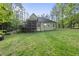 Backyard view showing the home's screened porch, well-maintained lawn, and wooded lot at 1211 New Grissom Way, Wake Forest, NC 27587