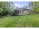 View of backyard and screened in back porch of home with trees in background at 1211 New Grissom Way, Wake Forest, NC 27587