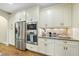 Well-lit kitchen featuring stainless steel appliances, granite countertops, and stylish white cabinetry at 1211 New Grissom Way, Wake Forest, NC 27587