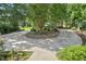 Circular driveway leads to a home surrounded by lush greenery, enhancing its secluded and private setting at 123 W Camden Forest Dr, Cary, NC 27518