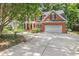 Traditional brick home featuring a two-car garage and lovely landscaping, enhancing the property's charm at 123 W Camden Forest Dr, Cary, NC 27518