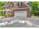 Spacious two-car garage attached to a brick home with a well-maintained driveway and green surroundings at 123 W Camden Forest Dr, Cary, NC 27518