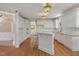 White kitchen with built-in appliances, breakfast bar, and hardwood floors at 123 W Camden Forest Dr, Cary, NC 27518