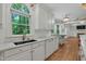 Gourmet kitchen featuring white cabinets, stainless steel appliances, and a view of the backyard at 123 W Camden Forest Dr, Cary, NC 27518