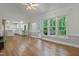 Bright living room featuring hardwood floors, large windows, and a seamless flow to the kitchen at 123 W Camden Forest Dr, Cary, NC 27518
