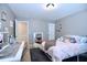 Well-lit bedroom featuring a comfortable bed, mirror, and neutral color scheme at 1254 Salters St, Burlington, NC 27215