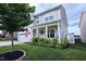 Inviting two-story home featuring a covered porch, lush landscaping, and an American flag at 1254 Salters St, Burlington, NC 27215