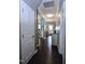 View of the hallway with dark wood floors leading to a living area with gray walls and white trim and doors at 1254 Salters St, Burlington, NC 27215